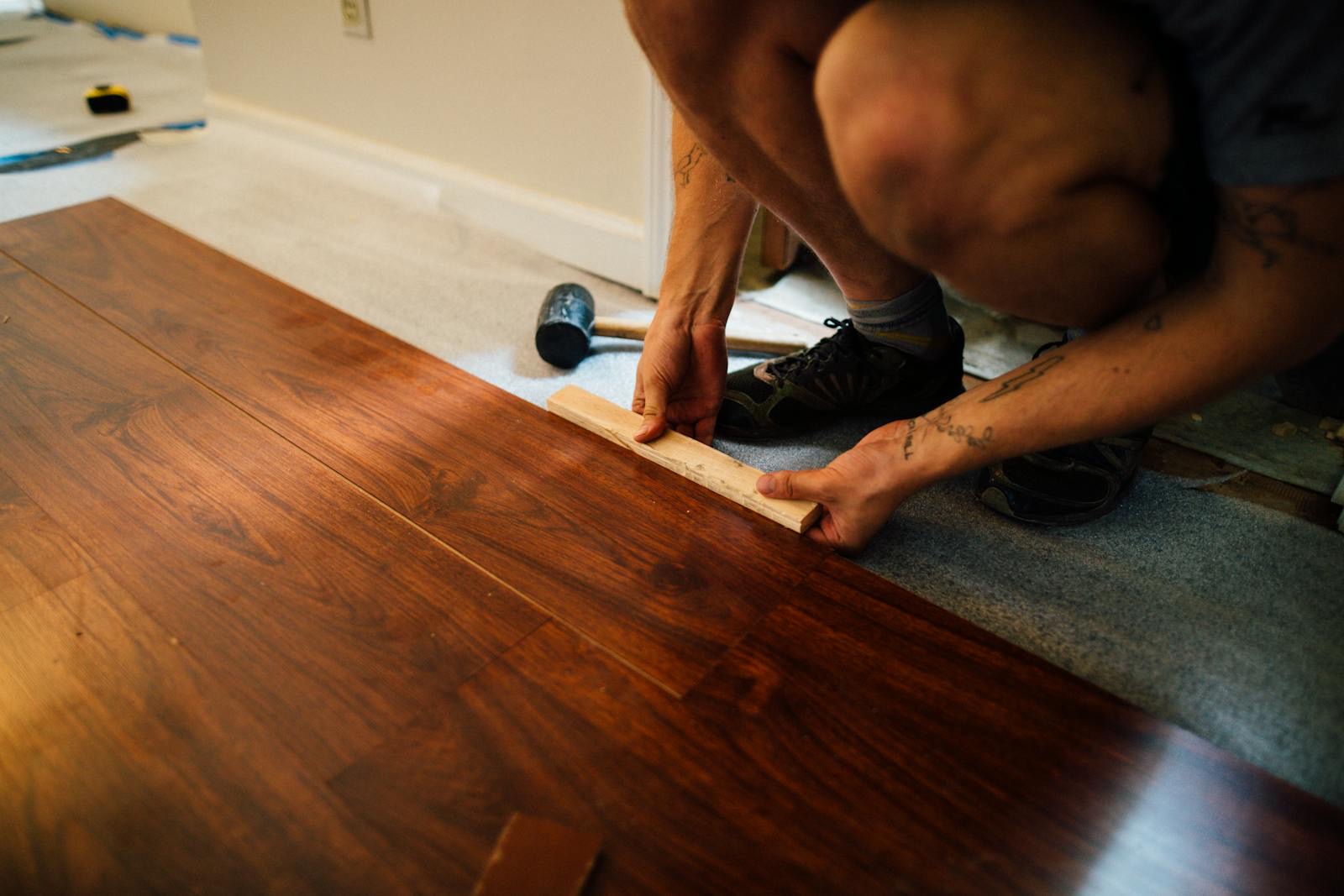 Professional flooring installer carefully laying new floor material